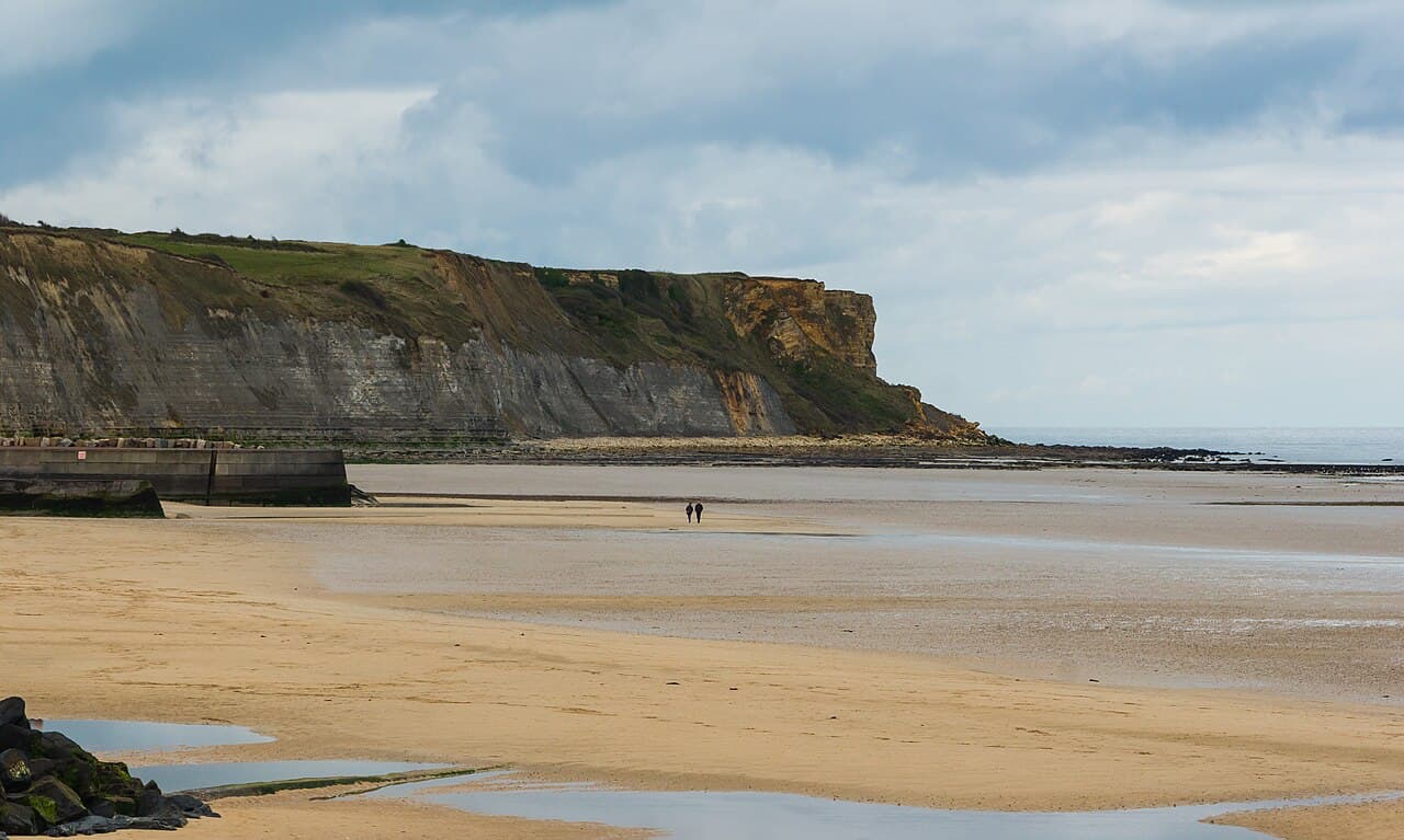 Gold Beach at Arromanches-les-Bains at low tide, under the cliffs of the British landing sector